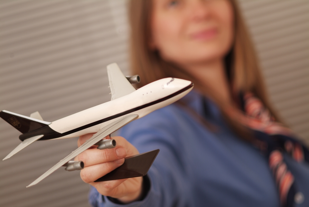 Travel Agent Holding Toy Jet 747 Airplane