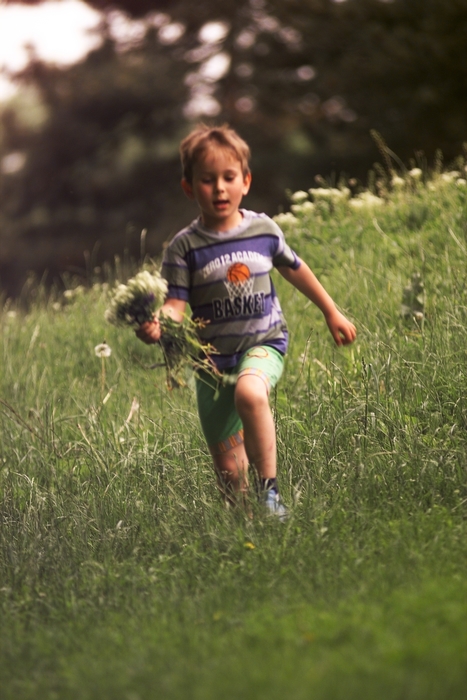Young Boy with Hand-Picked Flowers Walking