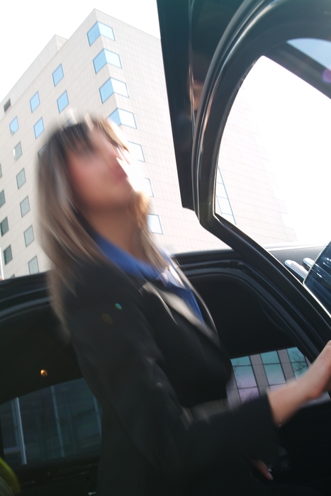 Businesswoman Getting Into a Limousine