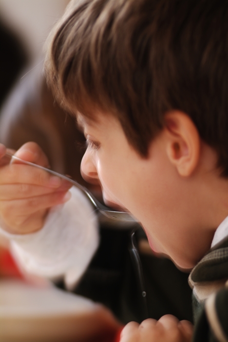 Young Boy Eating Soup with Spoon