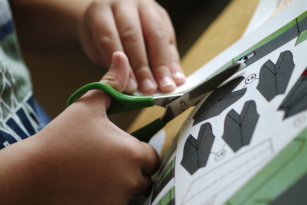 Child Cutting Paper with Scissors