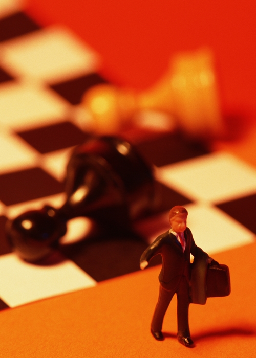 Toy Person and Fallen Pawns on a Chess Board