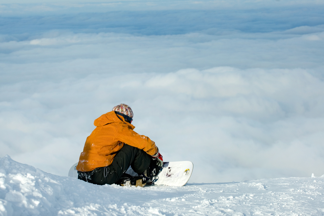 Snowboarder siting on snow